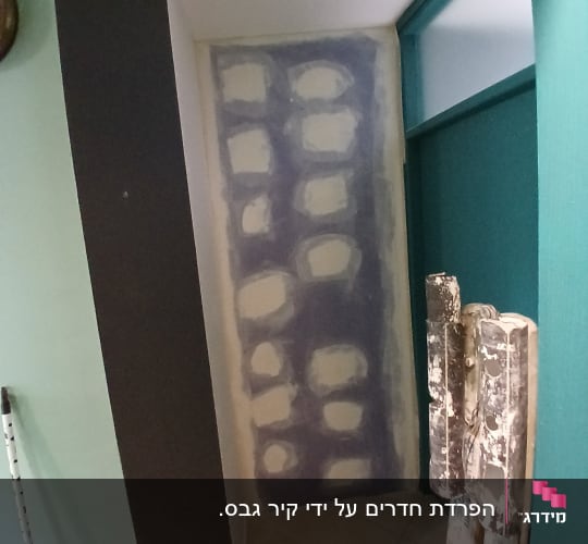 קיר גבס בתהליך עבודה עם שפכטל על הברגים והחיבורים